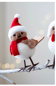 Close-up of a festive plush bird ornament with a red Christmas hat and warm scarf