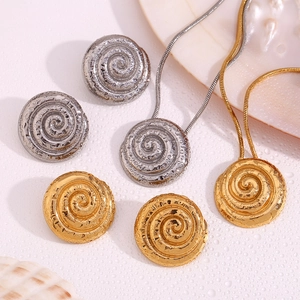 Detailed view of spiral texture gold and silver necklaces with matching stud earrings
