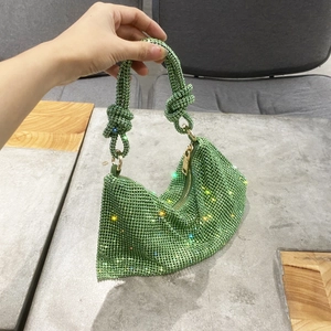 Detail of emerald green rhinestone evening bag featuring a unique knotted handle design