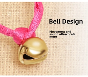Macro shot of a golden bell accessory with pink braided cord for interactive pet collars