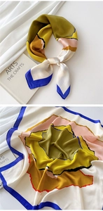 Detailed view of silk square scarf featuring abstract color blocks and royal blue edges