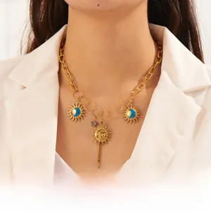 Detailed close-up of bohemian gold chain necklace with sun, moon and star pendants