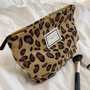 Vintage leopard print corduroy makeup bag with metal zipper on a white textile background
