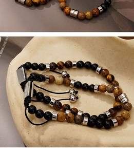 Detailed shot of tiger eye and black bead bracelets on a stone tray with adjustable cords