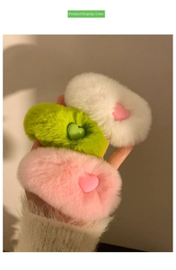 Close-up of three plush heart hair clips in pink, green, and ivory white fluffy rabbit fur
