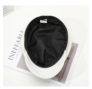 Detail view of white newsboy hat showing inner black lining and sweatband quality