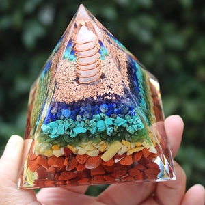 Handcrafted resin energy pyramid with layered natural crystal stones and copper coil spiral