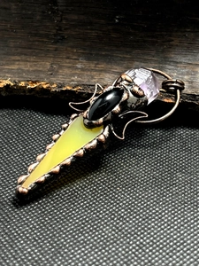 Macro shot of retro bronze pendant with agate, amethyst and copper wire wrapping
