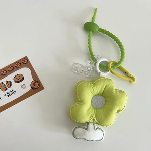 Détail d'un pendentif floral en peluche avec cordon en silicone vert et boucle en métal