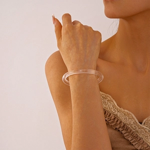Detail view of a vintage amber acrylic geometric round bangle worn on woman wrist