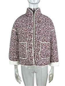 Detail of dark burgundy floral quilted jacket with white contrast piping and stand collar