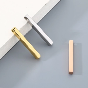 Three minimalist bar pendants in gold silver and rose gold finishes on a textured base