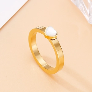 Detailed top view of gold minimalist ring featuring a white heart-shaped stone accent