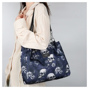 Detailed shot of dark blue tote bag with skull pattern and metal logo plate
