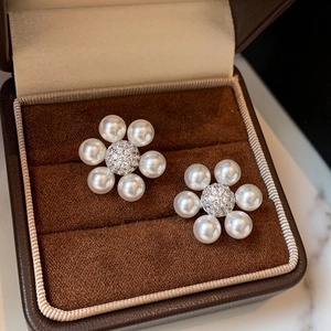 Boucles d'oreilles fleurs en zircon et perles présentées dans un écrin de luxe