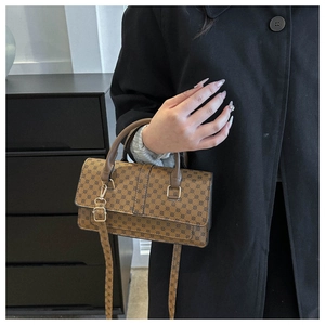 Detail showing vintage brown patterned handbag with gold hardware and top handle