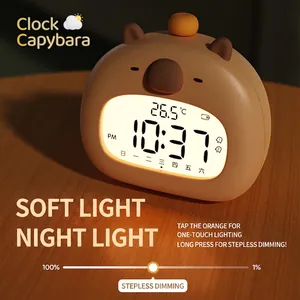 Capybara digital alarm clock with orange night light button on a wooden desktop