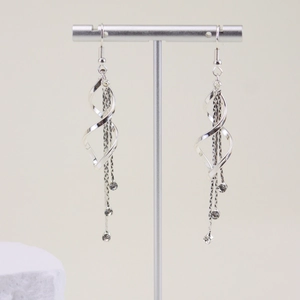 Silver long tassel earrings with spiral metal and rhinestones on a display stand