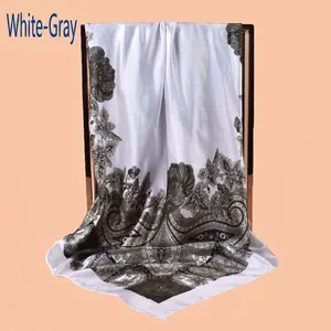 Detailed view of white and grey silk scarf featuring classic paisley and floral patterns