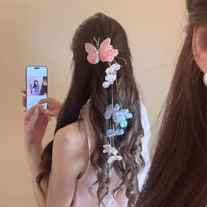 Detail of fabric butterfly hair clip with long floral tassels and pearls on hair