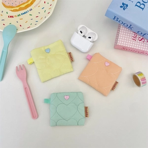Quilted heart-shaped mini earphone pouches in yellow, orange, and mint green colors