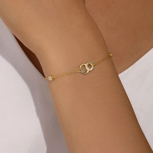Detailed view of gold S925 silver double-ring bracelet with luck engraving and zircon on wrist