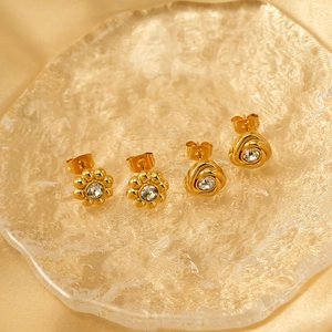 Golden flower and knot earring set with sparkling crystals on champagne silk background