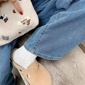 Flat lay of a Japanese style embroidered cotton cat cosmetic bag with beige sandals