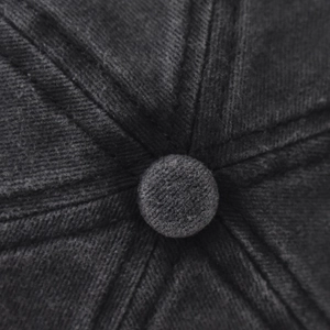 Vue macro du bouton supérieur et des coutures d'une casquette de baseball gris foncé
