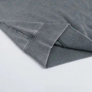 Macro detail of washed grey sweatshirt showing ribbed cuffs and heavy french terry fabric