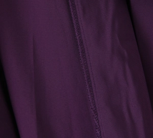 Detailed macro view of purple chiffon fabric texture and professional seam stitching