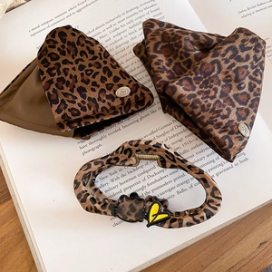 Detail of leopard print hair claw with cat motif and vintage fabric accessories
