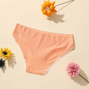 Detailed macro view of light orange ribbed knit polyester fabric on women's low-waist panties