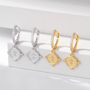 Detail of S925 silver hoop earrings with gold plating and engraved star coin charms