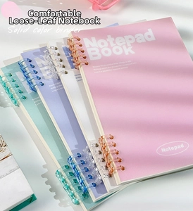 Detailed side view of colorful spiral binders on Morandi style loose-leaf notepads