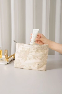 Détail de la trousse de maquillage en coton et lin avec broderie florale et fermeture éclair