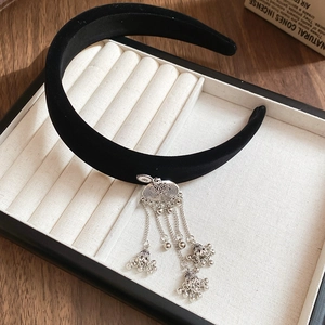 Detail of black velvet headband with ethnic silver bell tassels and floral engraving