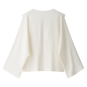 Women's white textured long-sleeve blouse with lace details and a relaxed silhouette
