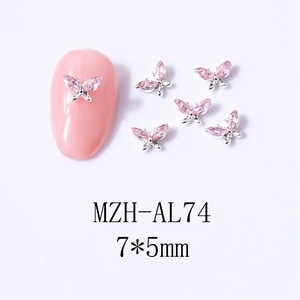 Macro detail of 7x5mm pink zircon butterfly nail charms with silver alloy base
