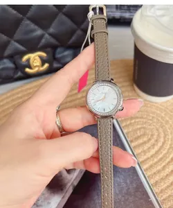 Detail of luxury women watch with taupe leather strap and mother-of-pearl diamond dial