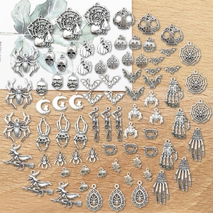 Detailed view of silver Halloween alloy charms featuring pumpkins and skeletons on wood