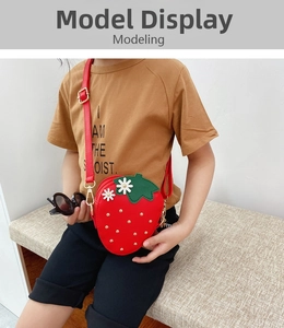 Detailed view of child wearing a strawberry shaped crossbody bag with floral accents