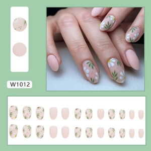 Short oval matte pink press-on nails set with white daisy and green leaf floral patterns