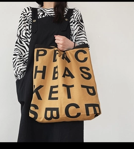 Detail of camel canvas tote bag featuring black letter print and durable thick fabric