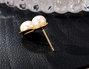 Close-up of S925 sterling silver hallmark and glossy pearl on the golden earring