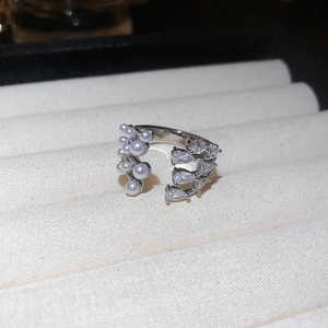 Detailed close-up of multilayer pearl ring with zircon accents in a velvet jewelry box