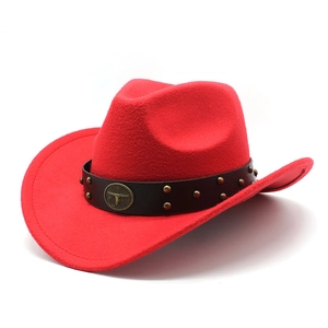 Détail d'un chapeau de cowboy en feutre rouge avec bande en cuir et emblème de taureau