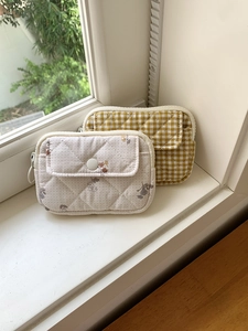 Quilted floral and mustard plaid multipurpose card pouches on a bright windowsill