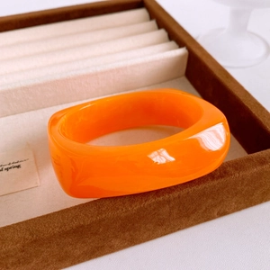 Detail of vintage orange resin cuff bracelet with marble texture in jewelry box