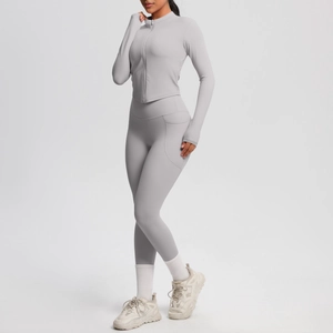 Détail d'un ensemble de yoga gris clair avec veste zippée et legging taille haute à poche
